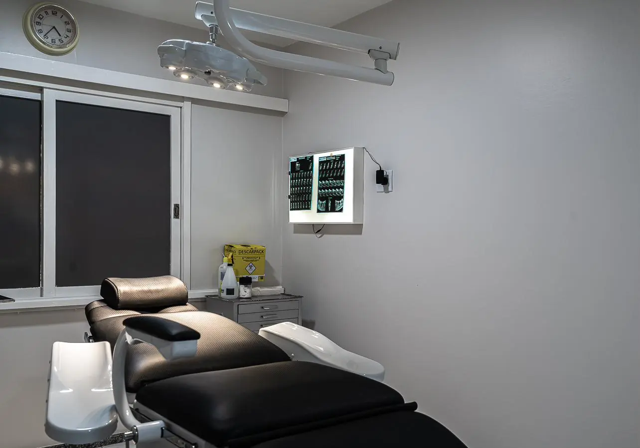 Foco cirúrgico, painel de radiografias e cadeira da sala cirúrgica